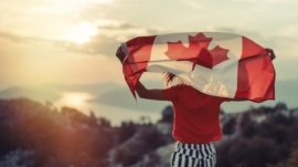 Happy child teenage girl waving the flag of Canada while running at sunset